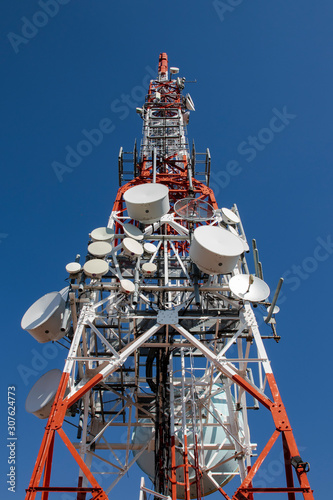 Telecommunications tower with antennas with blue sky.