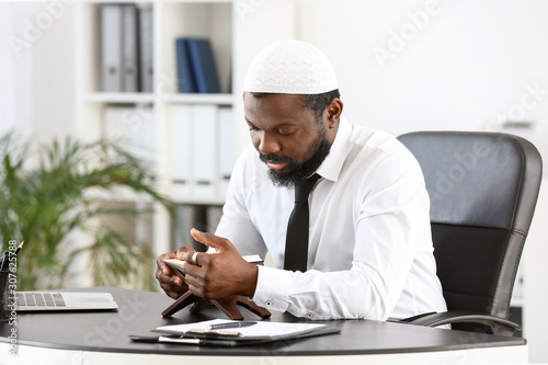 Photography African-American Muslim man praying in office