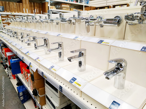 Various taps for bath and shower are sold in a large building materials supermarket