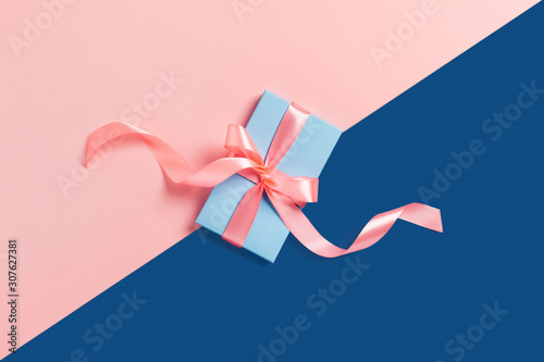 Holiday card. A blue box with a pink bow on two-toned background.