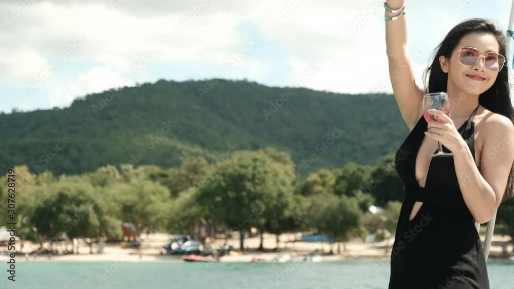 Asian black dress hold wine glass and say hello with other friend on yacht boat. Asian black dress hold wine glass and say hello with other friend on yacht boat.