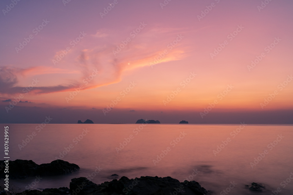 Spectacular sunset over rocky beach on a tropical island