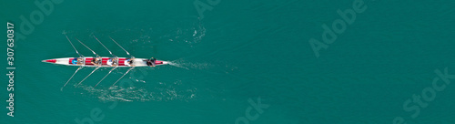 Aerial drone top panoramic view of sport canoe rowing synchronous athletes competing in tropical exotic lake