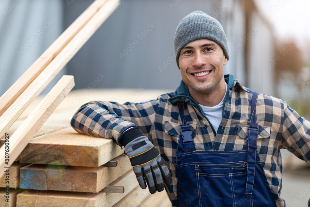 Young male worker in timber warehouse  - obrazy, fototapety, plakaty 