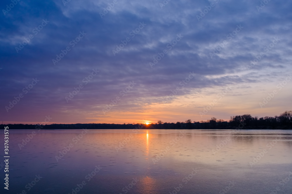 Ice on the frozen Lake and cirrus clouds in the sky before sunrise. Beautiful ukrainian landscape