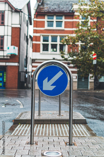 blue sign with white arrows on a street showing which h way to go. Copy space.