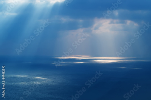 Sunlight through the clouds to the ocean water aerial