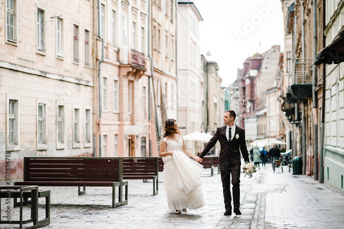 A loving wedding couple are walking along the streets of the city of Lviv. Newlyweds are walking. Wedding walks.