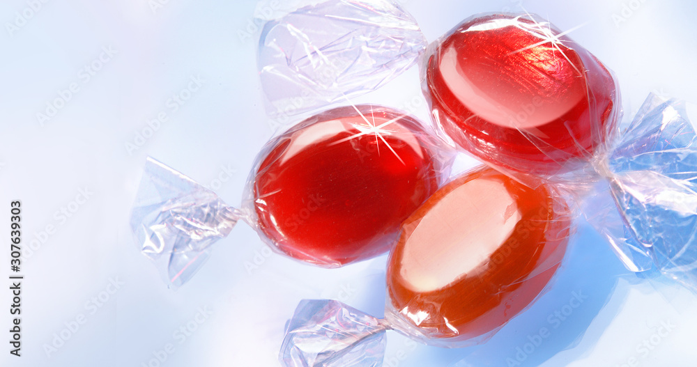 Verpackte rote Bonbons auf hellblauen Grund Verpackte rote Bonbons auf hellblauen Grund