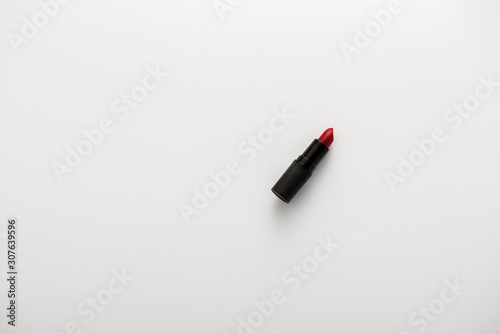 top view of tube with red lipstick on white