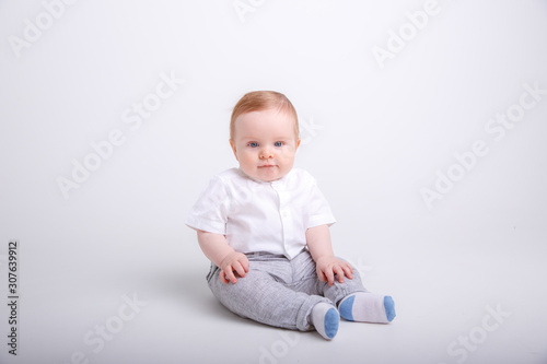 baby boy sitting on a white background. portrait of a child isolated on white background