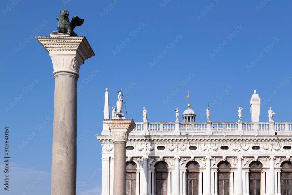 Detail of Pillar with a lion isolated against a blue sky in front of the Biblioteca Nazionale Marciana or the National Library in Venice, Italy