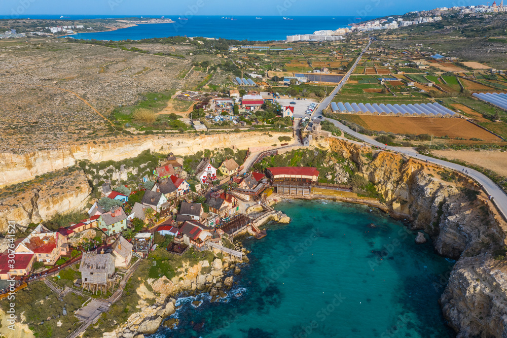Top view of famous tourist attraction Popeye village, also known as Sweethaven village. Sunny day, blue sea. Mellieha city. Malta 