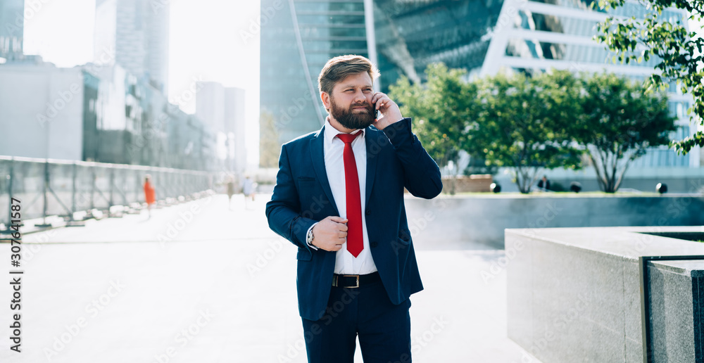 Serious business man in suit and red tie talking on phone Serious business man in suit and red tie talking on phone