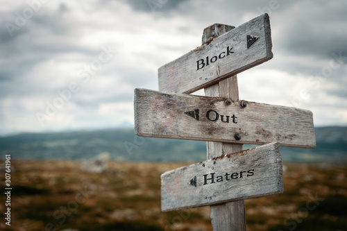 Fotografi Block out haters text on wooden rustic signpost outdoors in nature/mountain scenery