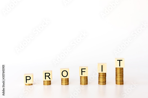 Business concept., Wooden cubes is on column coin with PROFIT word (is means business success, profit of invest) on white background with copy space for text.