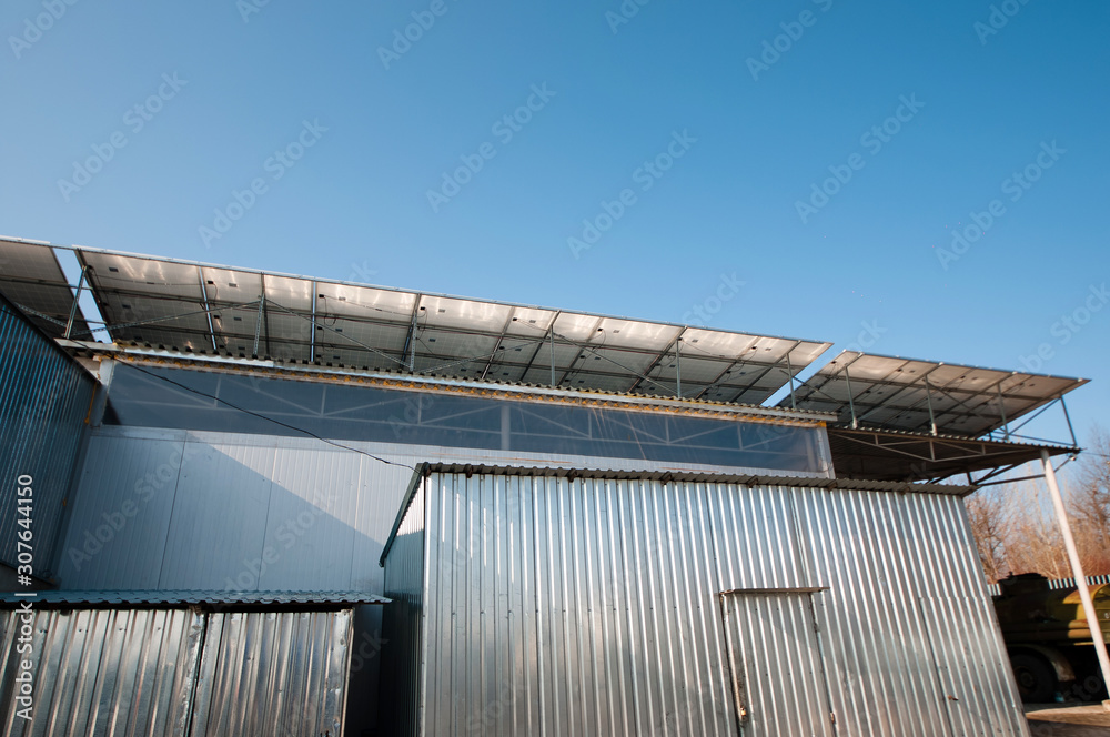 Solar panel system on house roof, sunny blue sky background.Blue solar panels. Solar panel system on house roof, sunny blue sky background.Blue solar panels.
