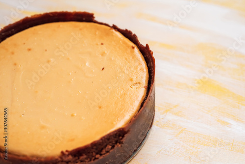 whole, freshly baked cheesecake on a neutral background