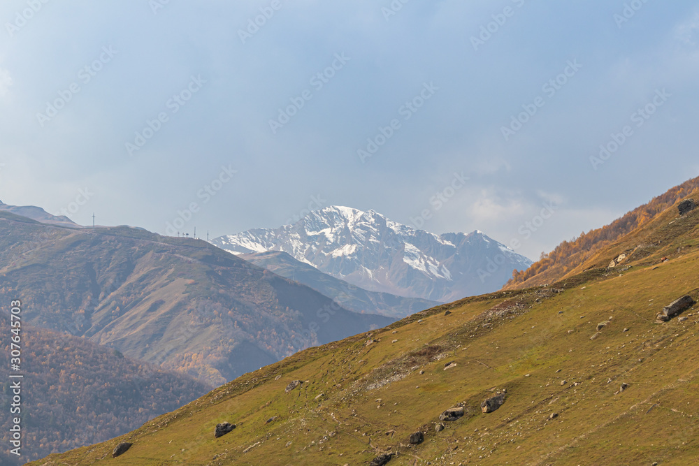 Green mountainside  on a background of snow-capped peaks in Svaneti in the mountainous part of Georgia