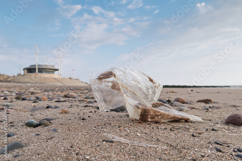 Plastic litter packaging and trash washed up on a sand and pebble beach. Environmental plastic pollution issue causing world  news. Health disaster on shores across the world. photo