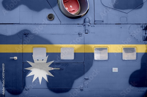 Nauru flag depicted on side part of military armored helicopter closeup. Army forces aircraft conceptual background photo