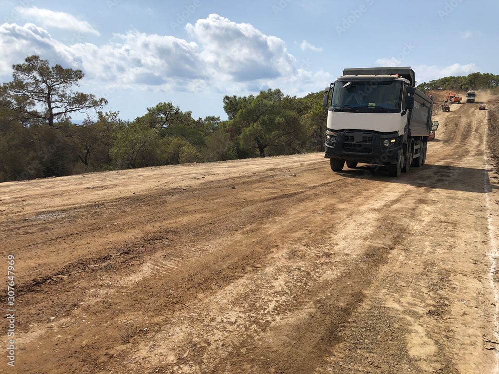 Truck carries excavated soil. Different types of machinery on the road construction works