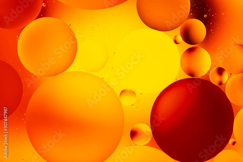 bright oily drops in water with colorful background, close-up 