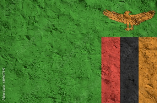 Zambia flag depicted in bright paint colors on old relief plastering wall. Textured banner on rough background photo