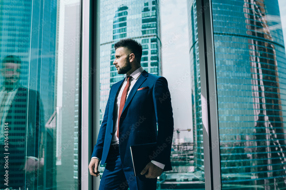 Fototapeta premium Dreaming businessman looking out window during work