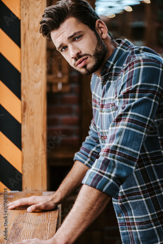 worried and bearded man looking at camera in barbershop
