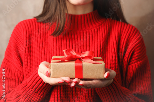 Young woman holding gift box, closeup. Space for text © Atlas