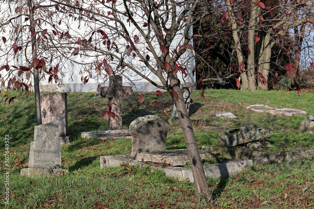 Tombstones in the old cemetery near a chapel Tombstones in the old cemetery near a chapel