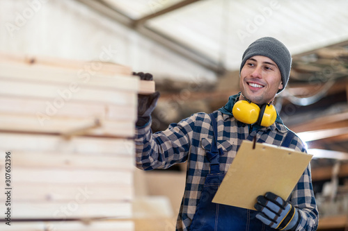 Young male worker in timber warehouse  photo