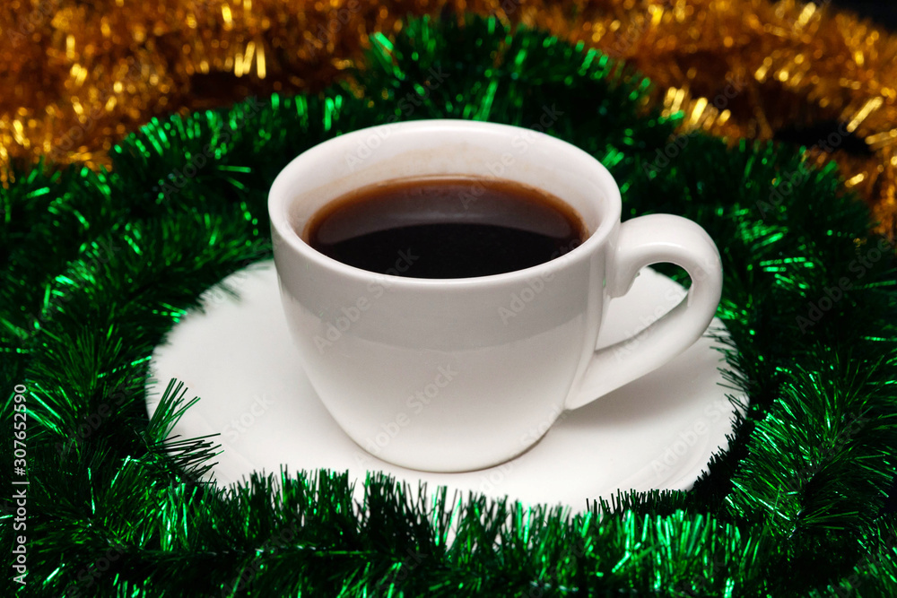 New Year coffee in little white cup and tinsel around. Christmas espresso New Year coffee in little white cup and tinsel around. Christmas espresso