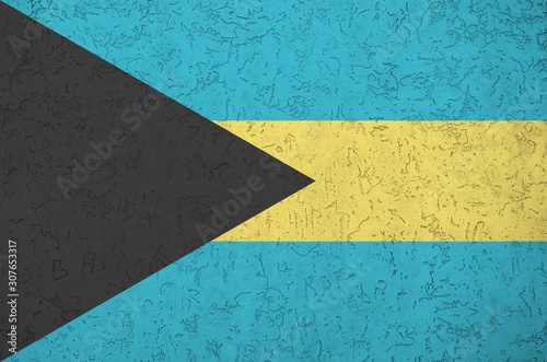 Bahamas flag depicted in bright paint colors on old relief plastering wall. Textured banner on rough background photo