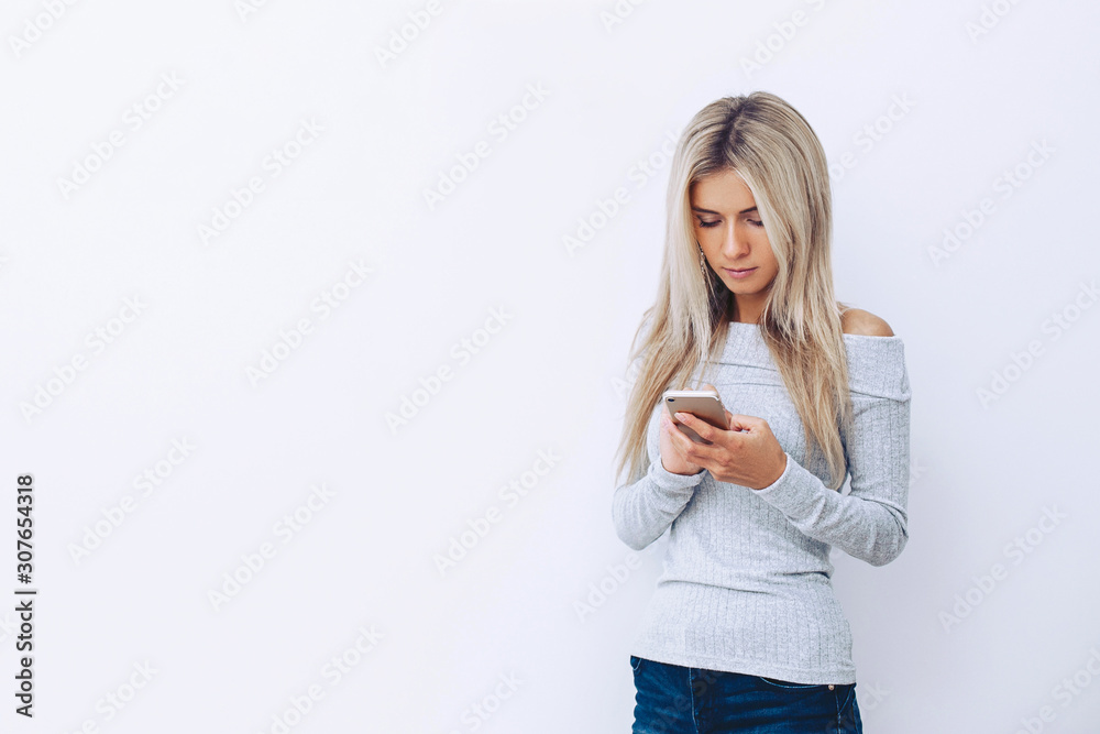 Young girl on a white background with a mobile phone in her hand