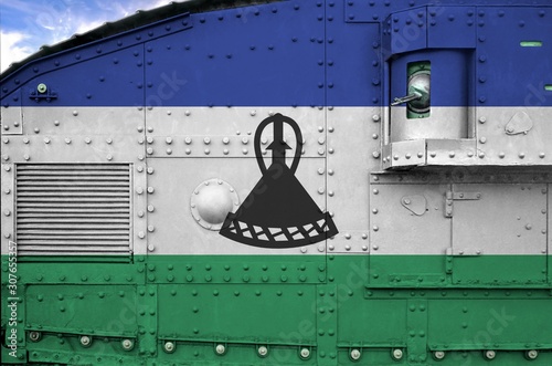 Lesotho flag depicted on side part of military armored tank closeup. Army forces conceptual background photo