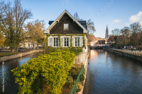 STRASBOURG, FRANCE - NOVEMBER 30, 2019: Traditional Alsatian half-timbered houses in Petite France, bridge and river embankment Ile during autumn day, Alsace, France