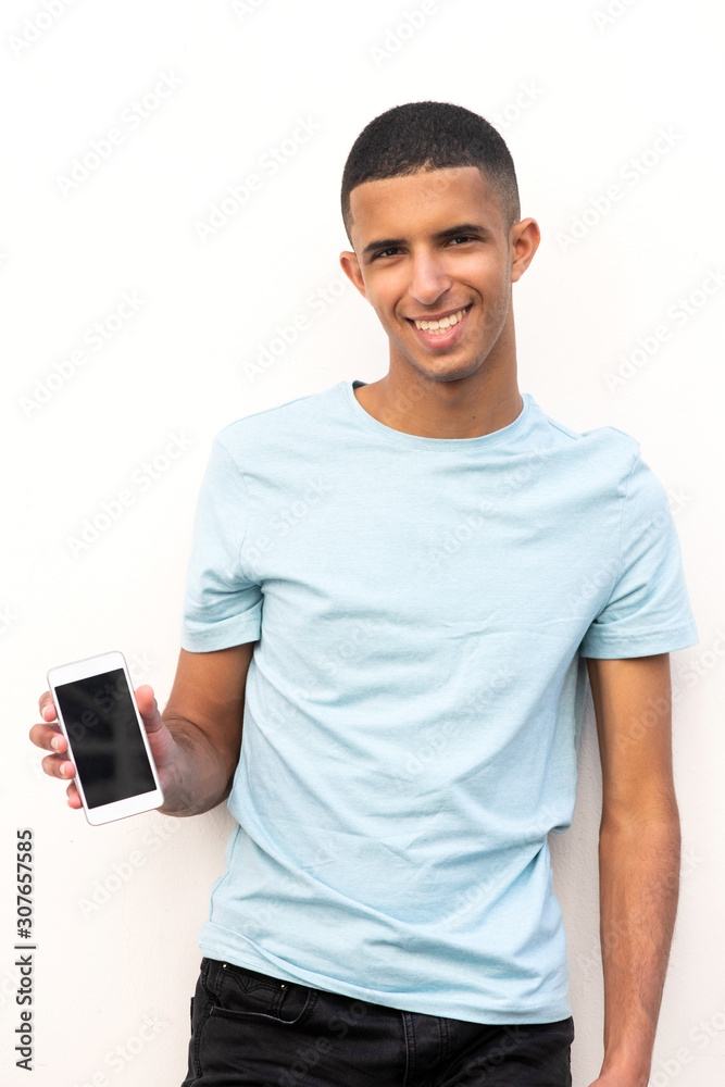 smiling young arabic man holding mobile phone and showing screen by white background smiling young arabic man holding mobile phone and showing screen by white background