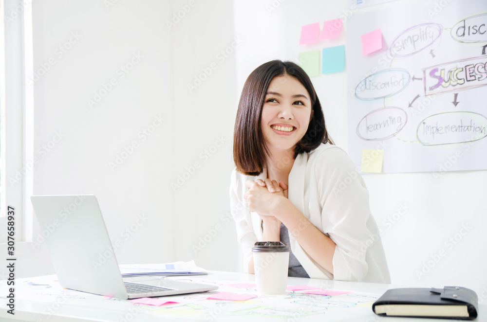 Smiling beautiful asian woman celebrate with laptop happy for success working. Agile for startup small business concept at modern office or co-working space with copy space for label text. Smiling beautiful asian woman celebrate with laptop happy for success working. Agile for startup small business concept at modern office or co-working space with copy space for label text.