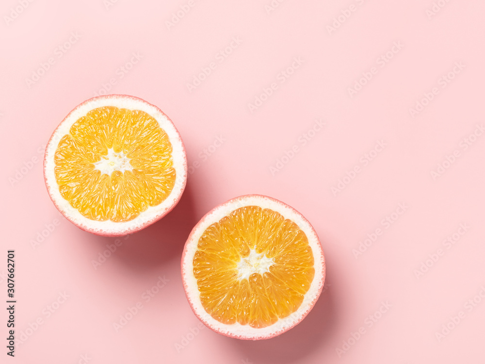 Sliced orange on a pastel pink background, top view, copy space, minimal. Sliced orange on a pastel pink background, top view, copy space, minimal.