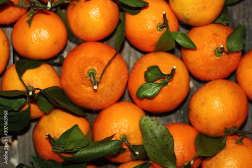 Juicy fresh tangerines with leaves on the table