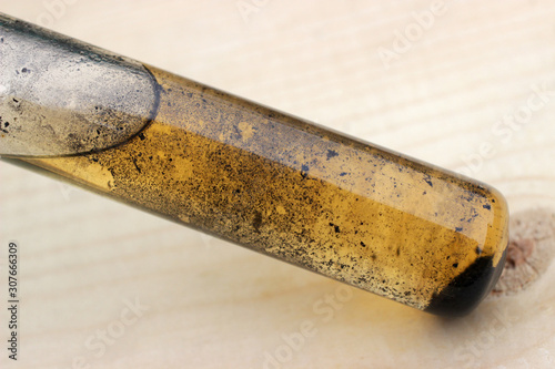 Small particles of iodine slowly settle in the solution at the bottom of the test tube.