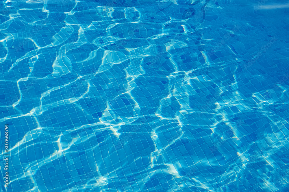 Ripple water in the swimming pool with sun reflection