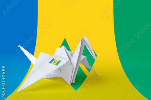 Saint Vincent and the Grenadines flag depicted on paper origami crane wing. Handmade arts concept photo