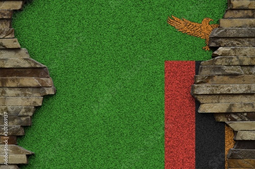 Zambia flag depicted in paint colors on old stone wall closeup. Textured banner on rock wall background photo