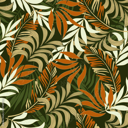 Fashionable seamless tropical pattern with bright orange and white plants and leaves on green background. Seamless pattern with colorful leaves and plants. Tropic leaves in bright colors.