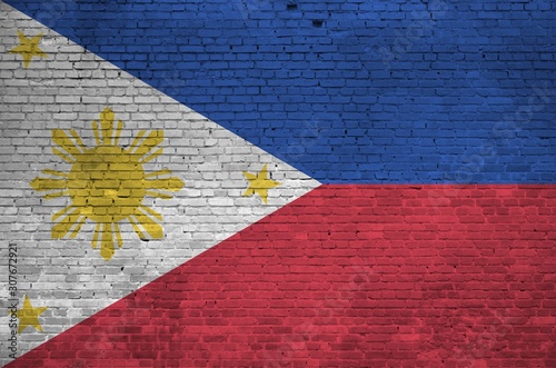 Philippines flag depicted in paint colors on old brick wall. Textured banner on big brick wall masonry background photo