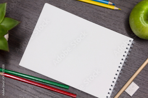 Mock up. A blank sheet surrounded by stationery for school, study. School day. The lessons. September 1. Dark wooden background.