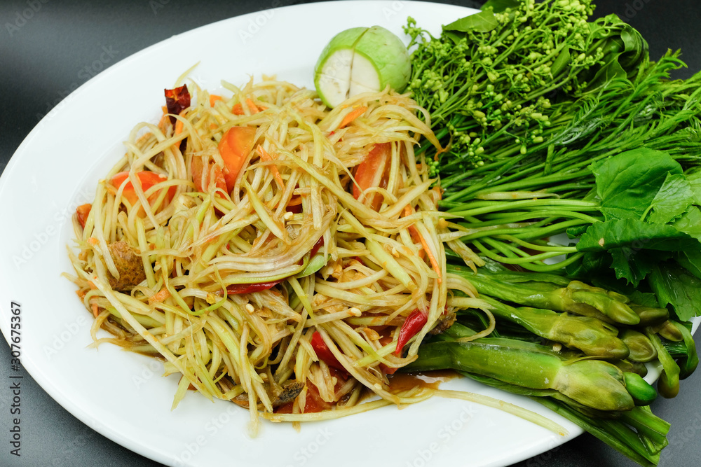 Thai style papaya salad with chilli, tomato and eggplant beside with varity of vegetable using as traditional food and asian hot dish concept. Thai style papaya salad with chilli, tomato and eggplant beside with varity of vegetable using as traditional food and asian hot dish concept.